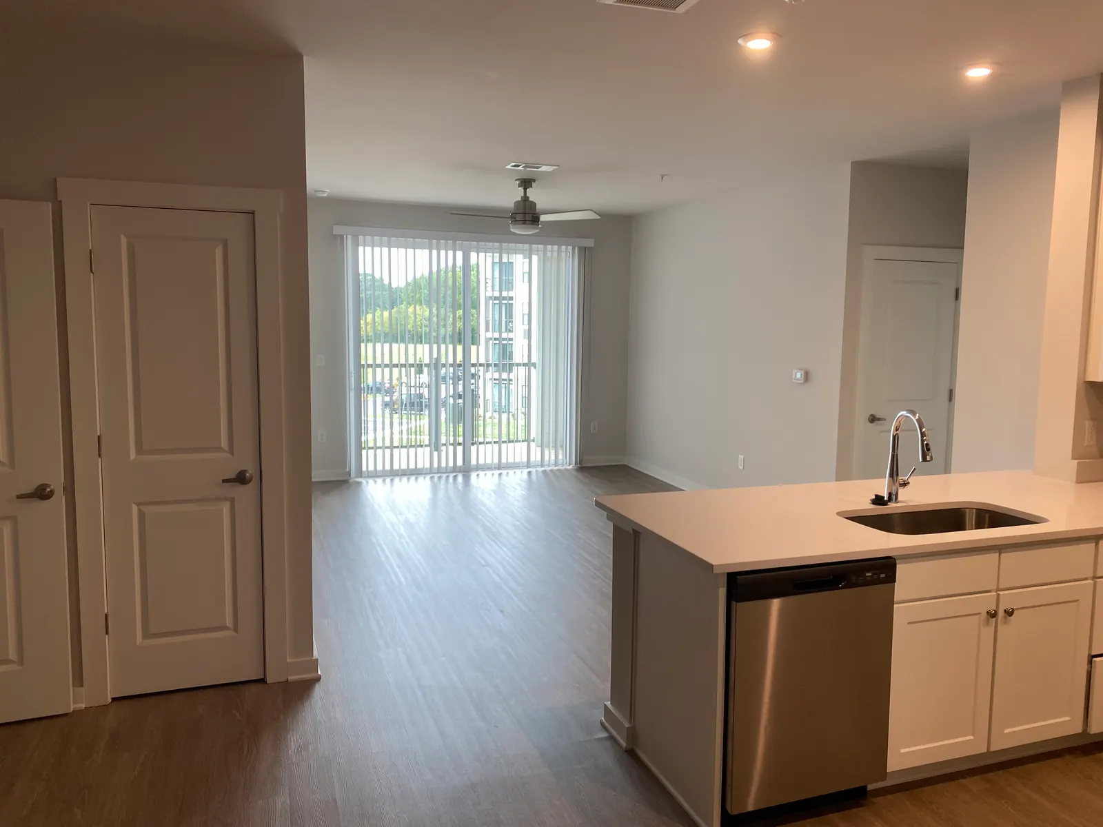 Newly painted apartment with white walls, a kitchen island and a balcony door