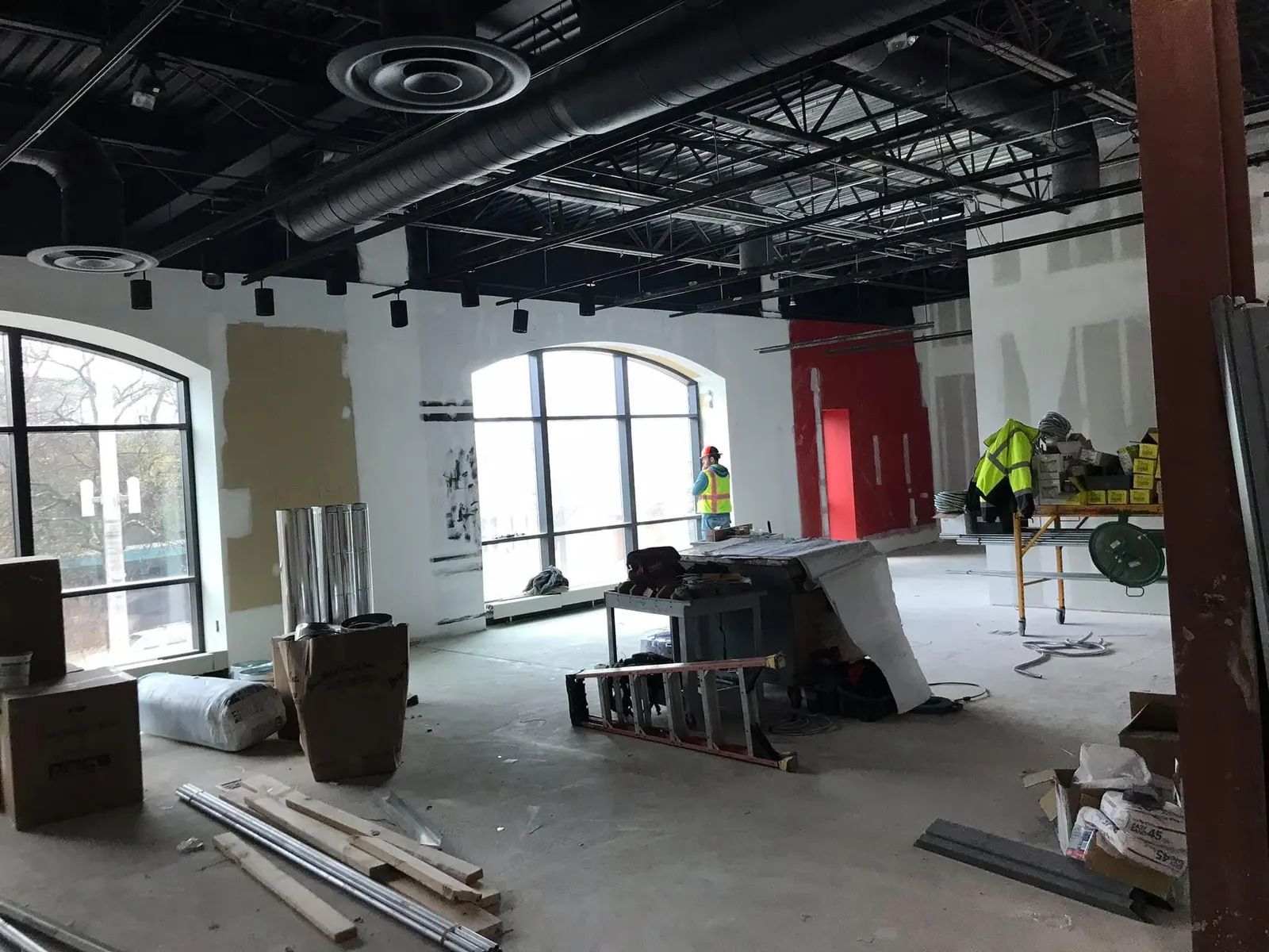 Commercial fit-out in progress with drywall patches and materials on the floor