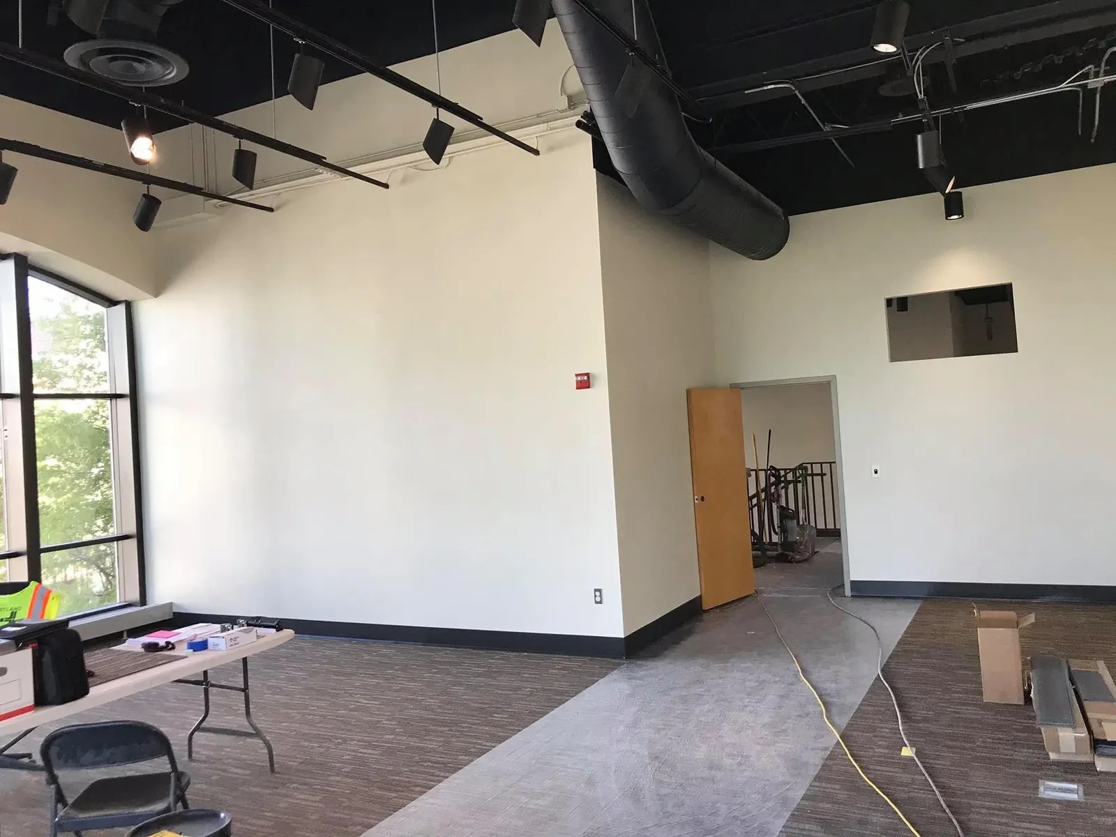 The same space with smooth white walls and a black open ceiling