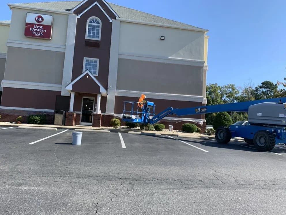 Hotel exterior with a boom lift parked beside it